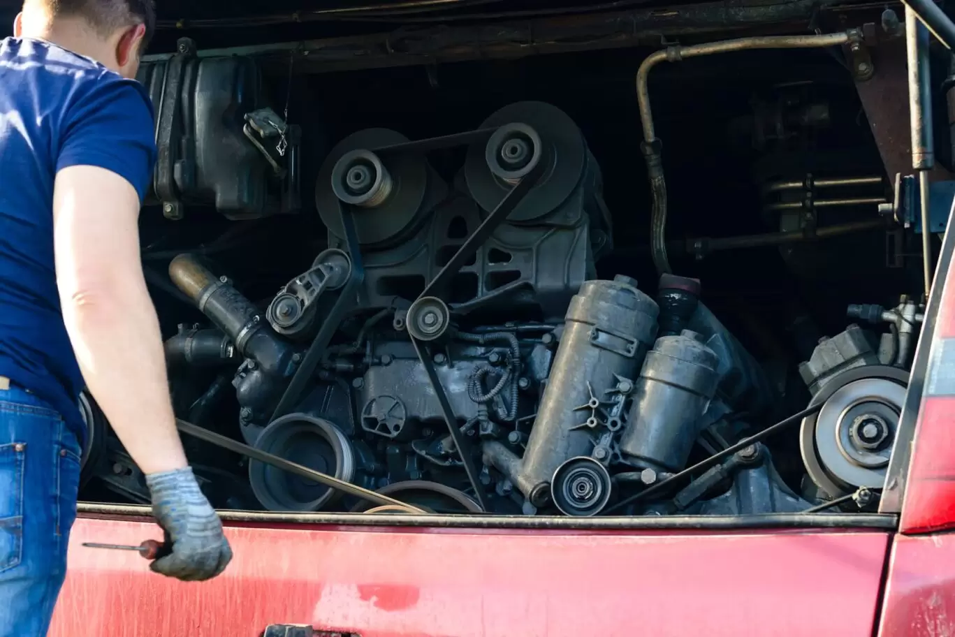 Mechanic looking at engine at front of a bus
