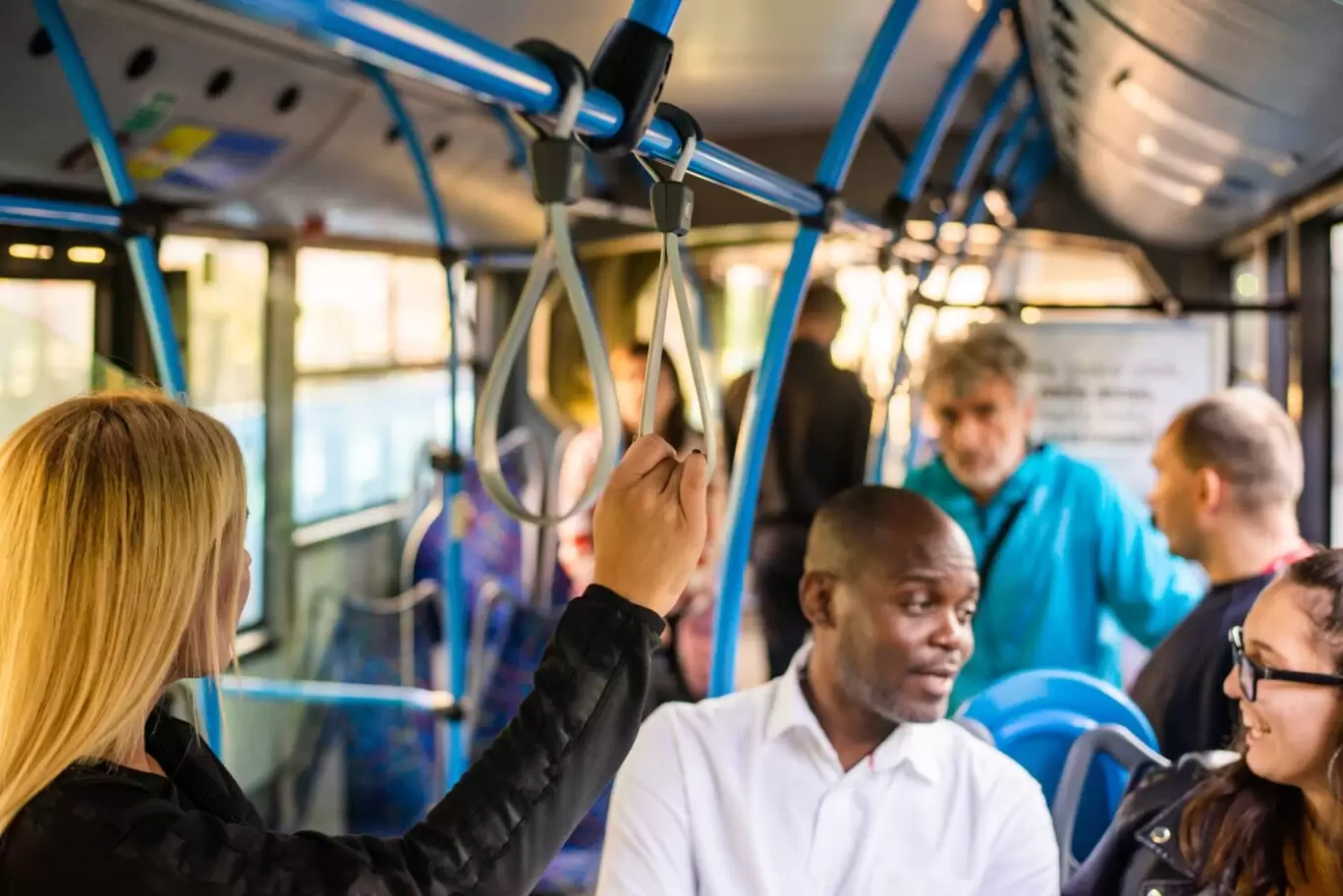 Passengers seated and standing on a bus