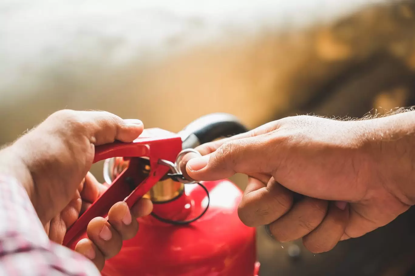Man pulling pin on fire extinguisher