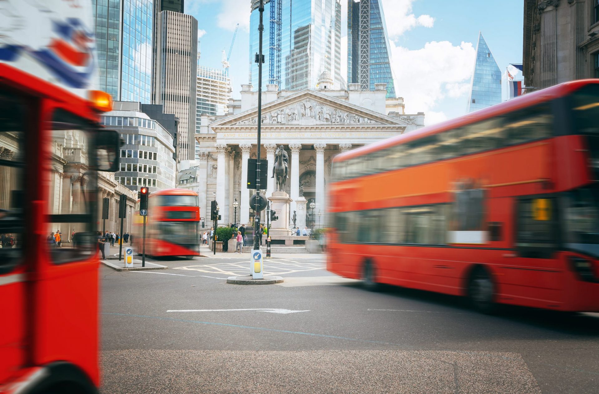 Red double decker buses in motion driving through London